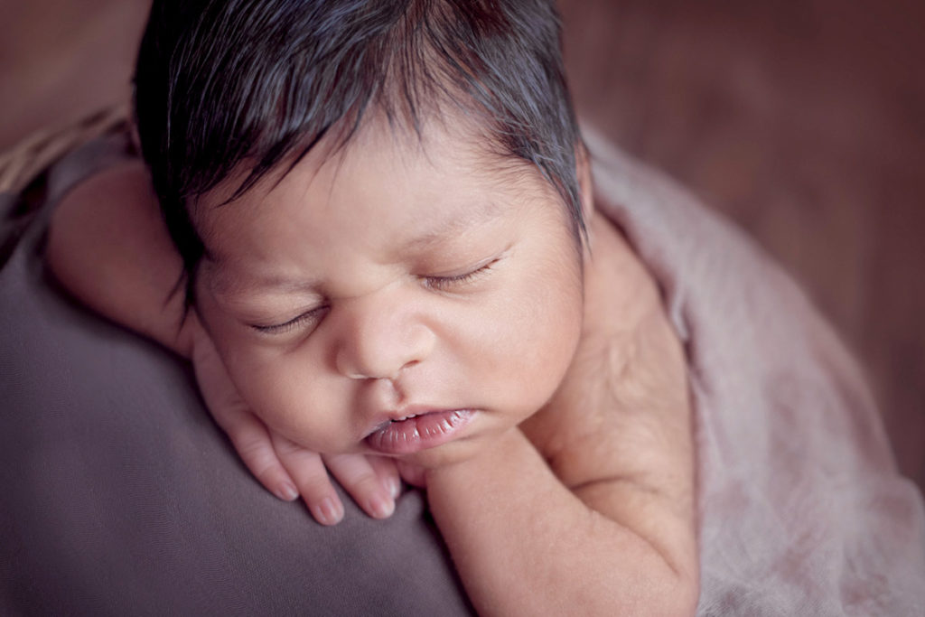 baby sleeping on arms photograph
